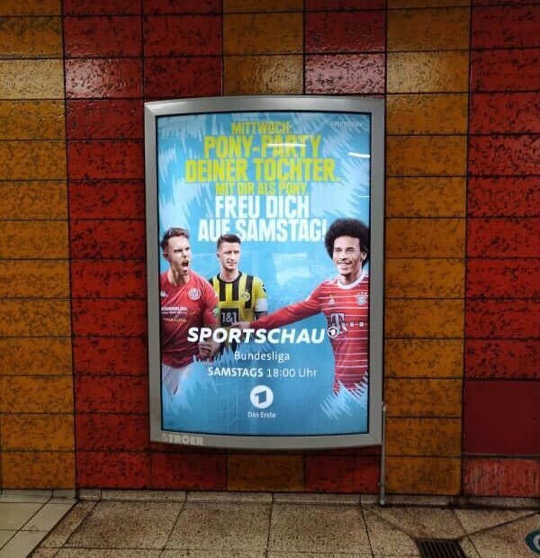 Das Bild zeigt ein Plakat an einer U-Bahn-Station, auf dem drei männliche Fußballspieler zu sehen sind. Dazu der Text: "Mittwoch: Pony-Party deiner Tochter mit dir als Pony. Freu dich auf Samstag!" Und darunter weiter: "Sportschau, Bundesliga, Samstags 18:00 Uhr, Das Erste".