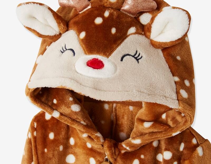 zu sehen ist die Kapuze und der obere Teil eines Overalls. Der flauschige Stoff ist rotbraun mit weißen Punkten, auf der Kapuze sind geschlossene Augen mit je 3 Wimpern, eine rote Nase, 2 glitzernde Geweihhöhrnchen und Ohren.