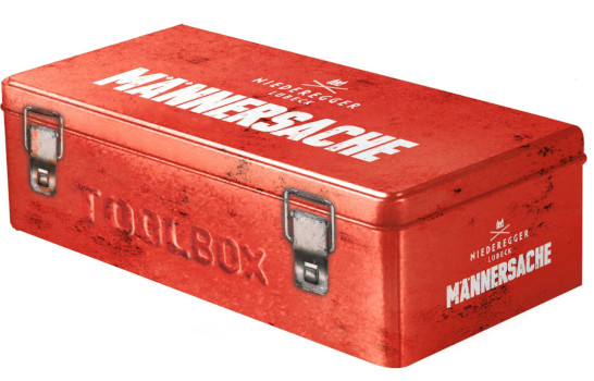 Ein rote Verpackung, die aussieht, wie eine Werkzeugkiste aus Metall mit der Aufschrift “Toolbox Männersache”