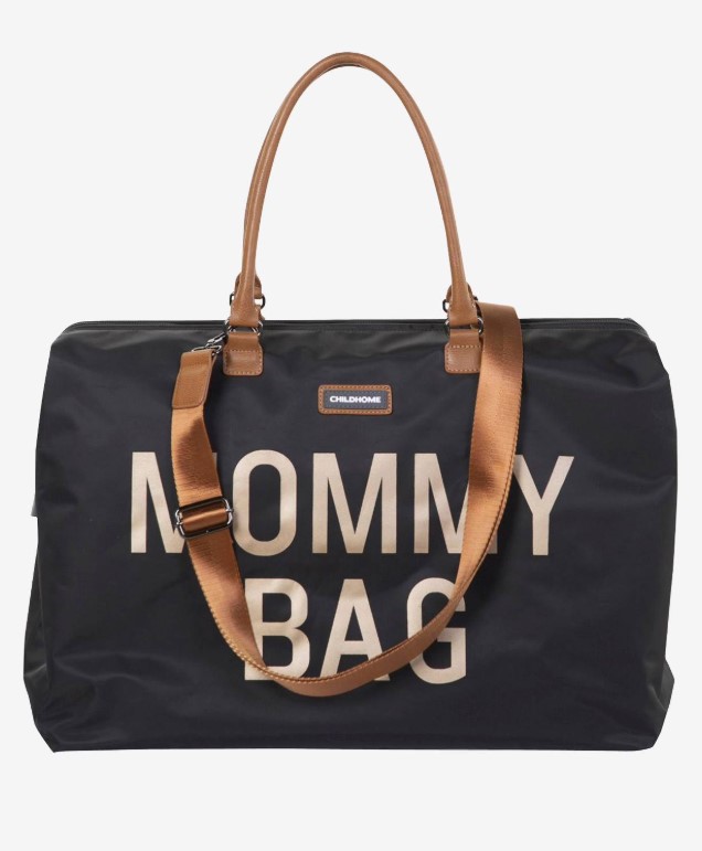 Die Mommy Bag ist eine weiße oder schwarze Wickeltasche mit einem länglichen, rechteckigen Körper. Sie besitzt einen Tragegriff oben sowie zwei seitliche Taschen und ein großes Fach auf der Vorderseite. Der Schriftzug 'Mommy Bag' ist mittig auf dem Vorderfach angebracht.