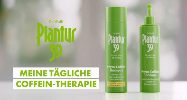 Werbeanzeige für Dr. Wolff Plantur 39 Haarpflegeprodukte mit Coffein-Therapie. Das Bild zeigt zwei grüne Produkte der Serie vor einem unscharfen, hellen Hintergrund: Rechts das Phyto-Coffein Shampoo in einer grünen Flasche mit Schraubverschluss, beschrieben als "aktiviert die Haarwurzel schon beim Waschen" und "speziell für coloriertes und strapaziertes Haar". Links das Phyto-Coffein Tonikum in einer grünen Flasche mit Pumpspender, das "schützt die Haarwurzeln" und "kräftigt das Haarwachstum". Beide Produkte sind für "das Haar ab Vierzig" konzipiert, wie auf den Flaschen angegeben. Links im Bild steht das große Plantur 39 Logo in grüner Schrift. Unten befindet sich ein weißer Textbalken mit der Botschaft "MEINE TÄGLICHE COFFEIN-THERAPIE" in grüner Schrift.