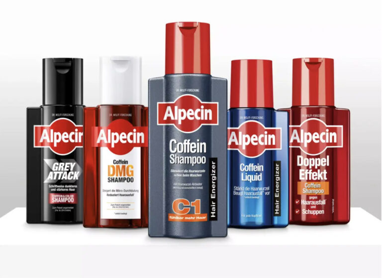 Produktaufstellung der Alpecin Haarpflege-Serie mit fünf verschiedenen Shampoo-Varianten für Männer vor weißem Hintergrund. Von links nach rechts: Grey Attack - Schwarze Flasche mit schwarzem Verschluss, speziell für grau werdendes Haar, mit der Aufschrift "Schrittweise dunkleres und stärkeres Haar" und "Coffein & Color Shampoo" Coffein DMG Shampoo - Weiße Flasche mit rotem Verschluss, bewirbt "Steigert die Mikro-Durchblutung" und "Reduziert Haarausfall" Coffein Shampoo C1 - Graue Flasche mit rotem Verschluss in der Bildmitte, das Flaggschiff-Produkt mit "Stimuliert die Haarwurzeln beim Waschen" und "fühlbar mehr Haar" Coffein Liquid - Blaue Flasche mit rotem Verschluss, Aufschrift "Stärkt die Haarwurzel" und "Beugt Haarausfall vor" Doppel Effekt - Rote Flasche mit rotem Verschluss, "Coffein Shampoo" gegen "Haarausfall" und "Schuppen"