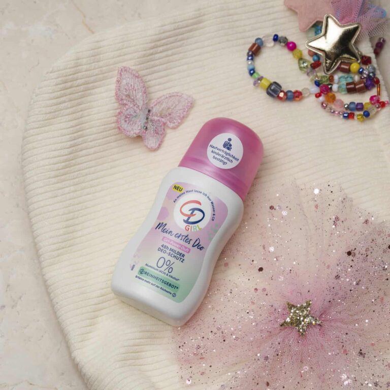 Das Bild zeigt das Produkt auf einem kindlich gestalteten Schminktäschchen liegen. Auf dem hellen Täschchen befindet sich außerdem ein rosa Schmetterling und ein pinker, glitzernder Tüllstoff. Oben rechts ist ein buntes Perlenarmband mit einem glänzenden Stern zu sehen.